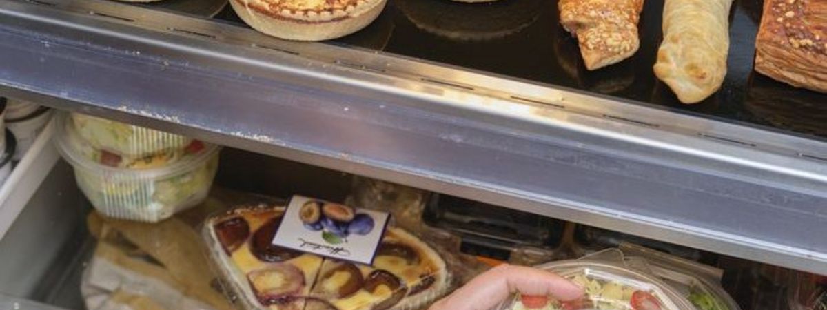 Un client d'une boutique de station-service choisir dans le rayon un plat frais Ă  emporter.