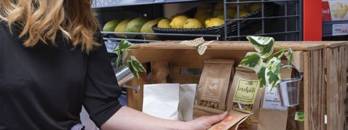Une client d'une boutique de station-service choisit un produit qui vient d'un producteur de la région.