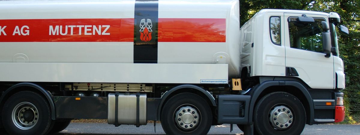 Der Heizöllieferwagen der Firma E. Schenk AG auf einem Parkplatz inmitten von Bäumen