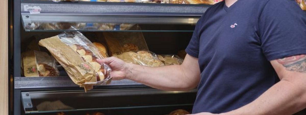Un client d'une boutique de station-service choisit dans le rayon du pain.