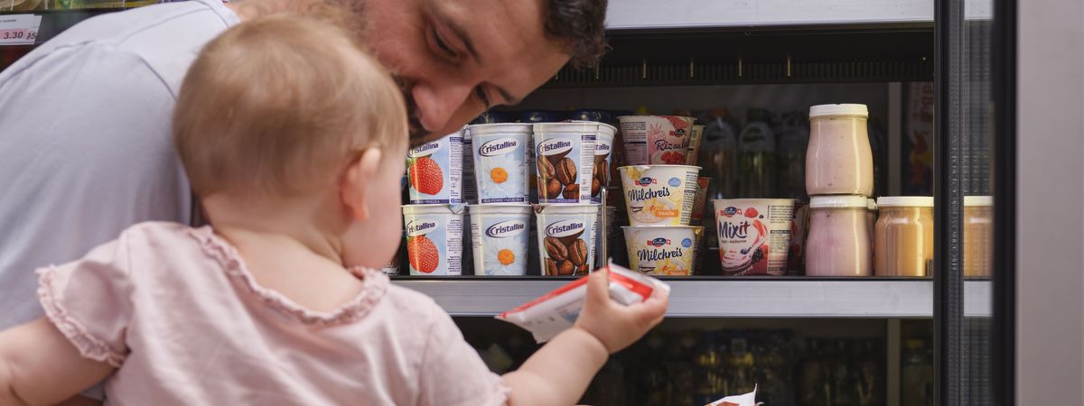 Un client d'une boutique de station-service choisit dans le rayon un produits pour laitier pour son enfant.